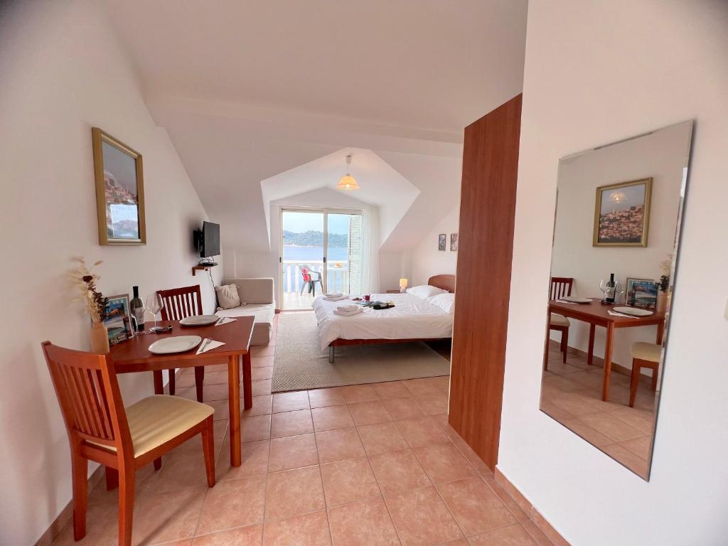 Terrace apartments في Ubli: غرفة معيشة مع سرير وغرفة طعام