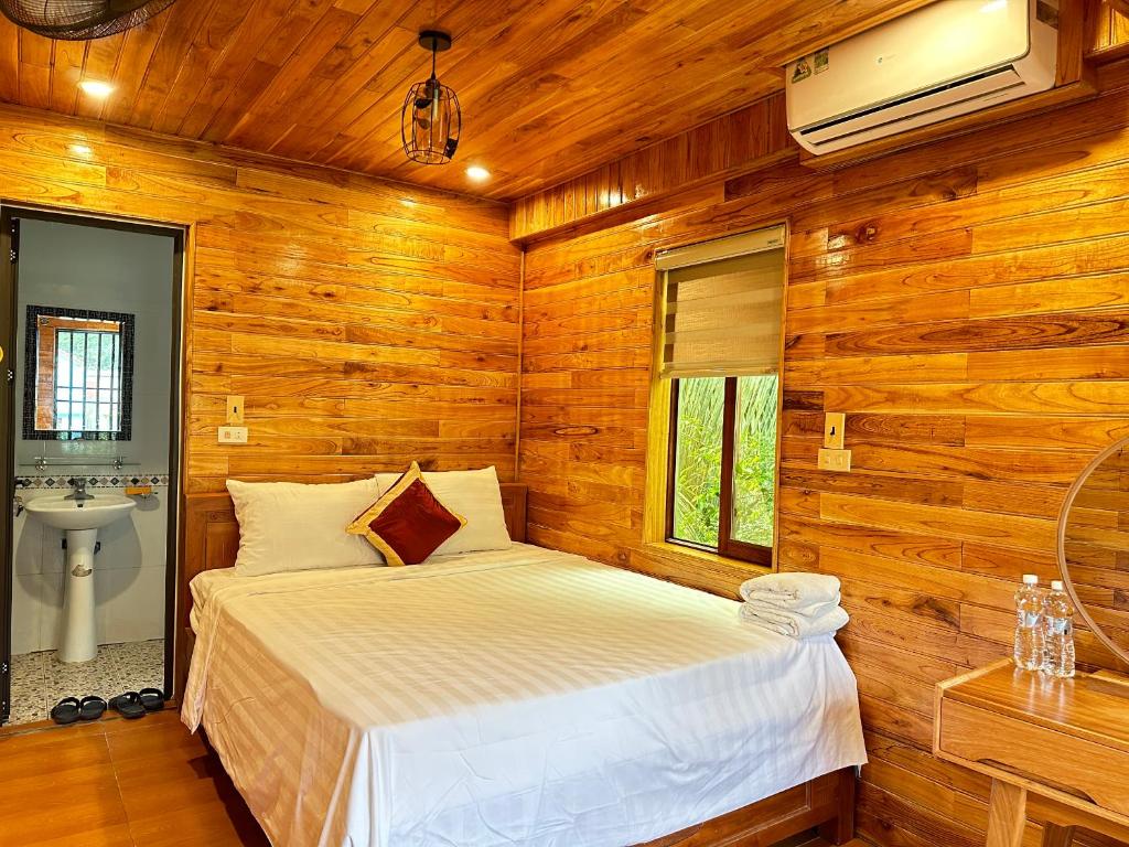 a bedroom with a bed in a wooden room at Tam Coc Rocky Hotel in Ninh Binh