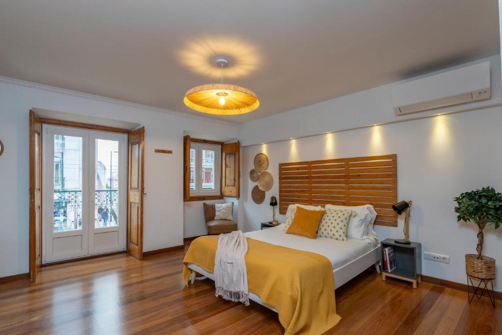 una camera con un grande letto con testiera in legno di Superb Apartments Overlooking Graça in Lisbon a Lisbona