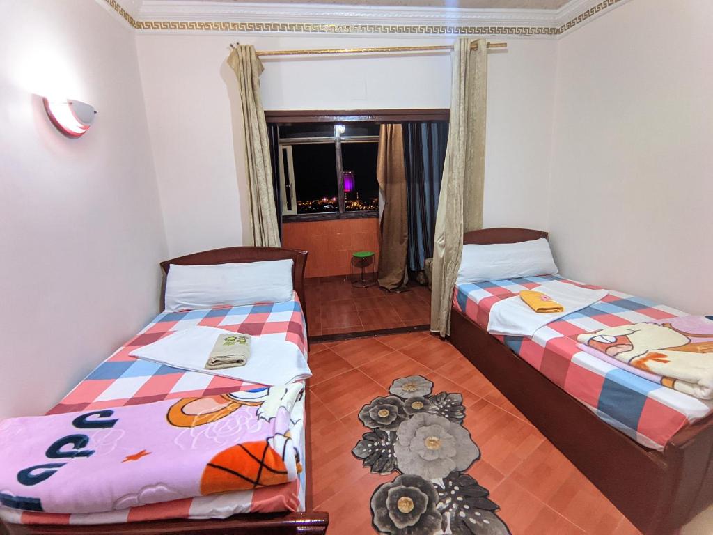 Zimmer mit 2 Betten und einem Spiegel in der Unterkunft TOP HOTEL in Assuan