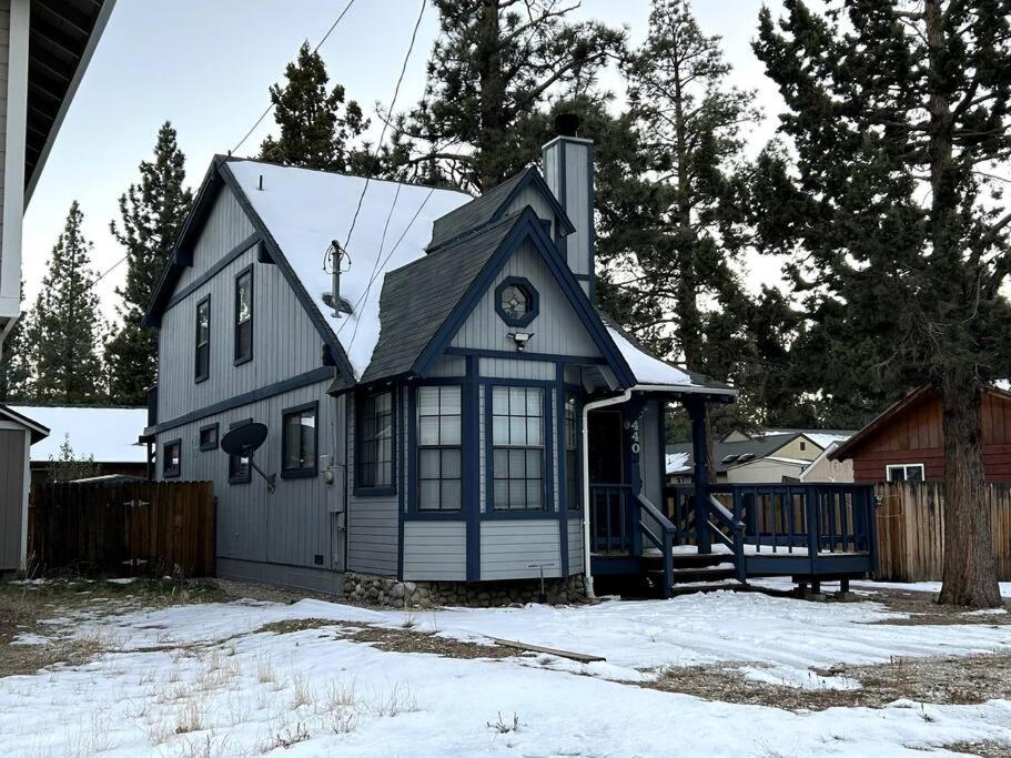 une maison bleue et blanche dans la neige dans l'établissement Cozy Modern Cabin, à Big Bear City
