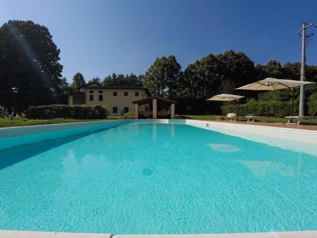 une grande piscine bleue avec une maison en arrière-plan dans l'établissement Ferienhaus mit Privatpool für 27 Personen ca 346 qm in Monsagrati, Toskana Provinz Lucca, à Monsagrati