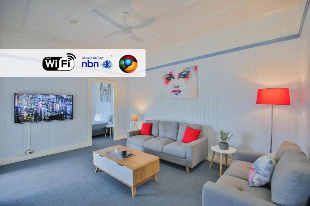 a living room with two couches and a tv at Park View Self-Contained in Bundaberg