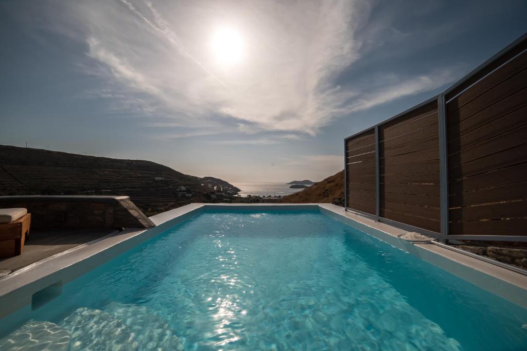 a swimming pool with the sun in the sky at Epithea Suites Kythnos 4 με ιδιωτική πισίνα in Kithnos