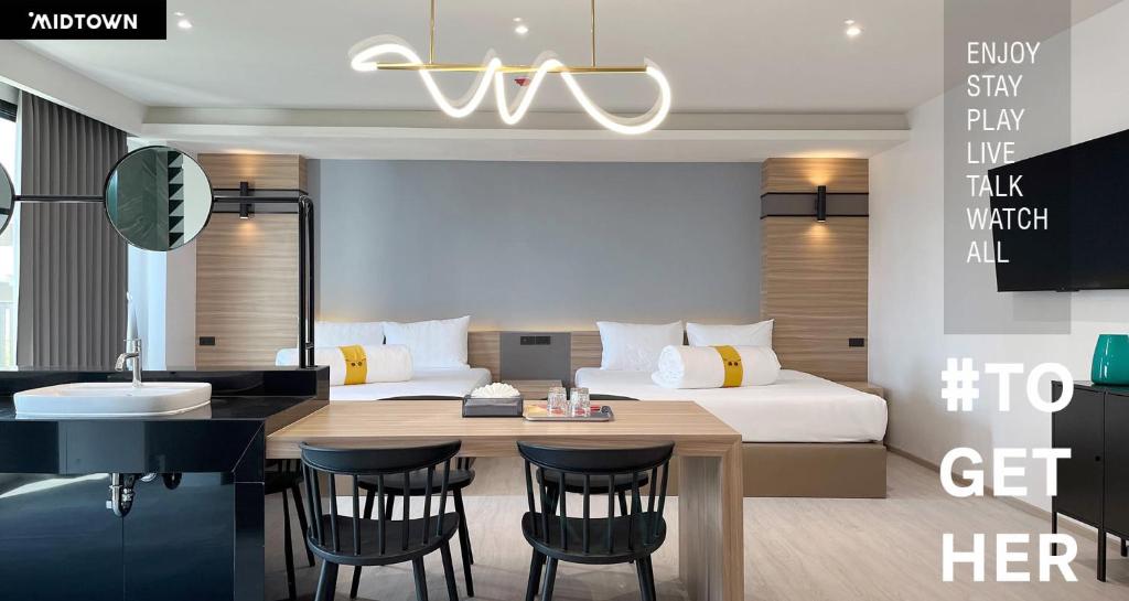 Hatyai Midtown Hotel في هات ياي: غرفة نوم بسرير ومطبخ مع طاولة