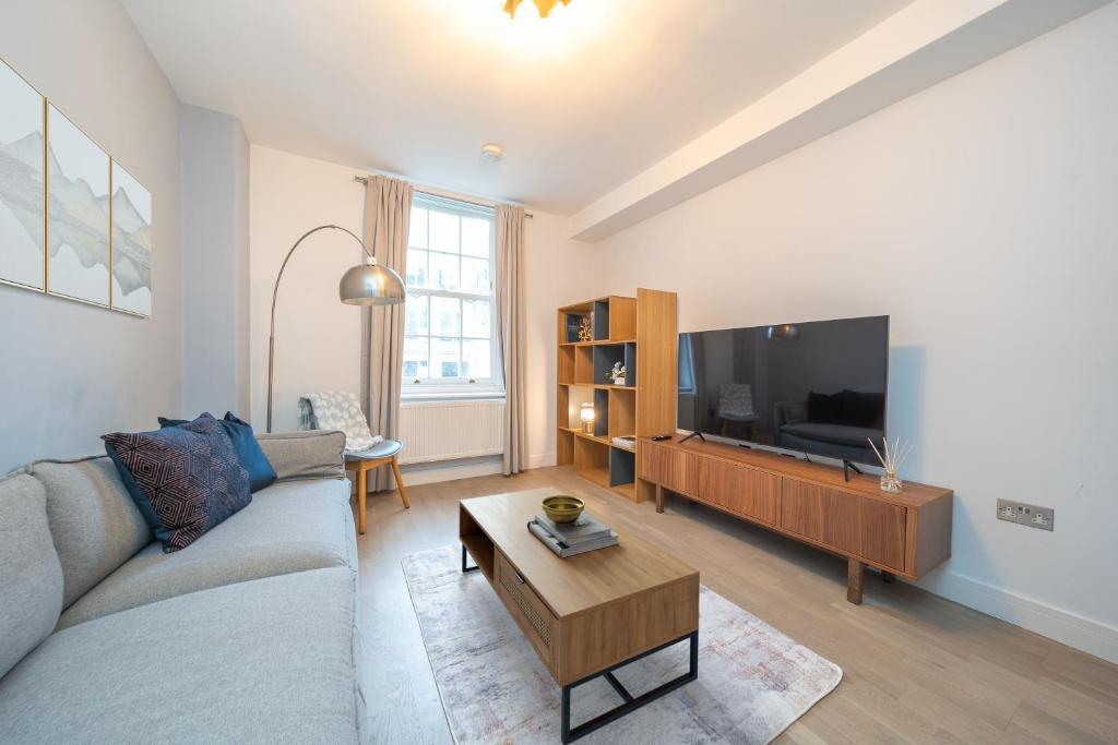 a living room with a couch and a flat screen tv at Charming 2 Bedroom Flat in Central London in London