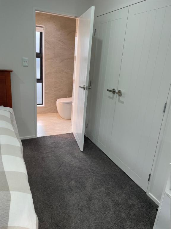 1 dormitorio con 1 cama y baño con aseo en 11A Addison street home stay, en Auckland