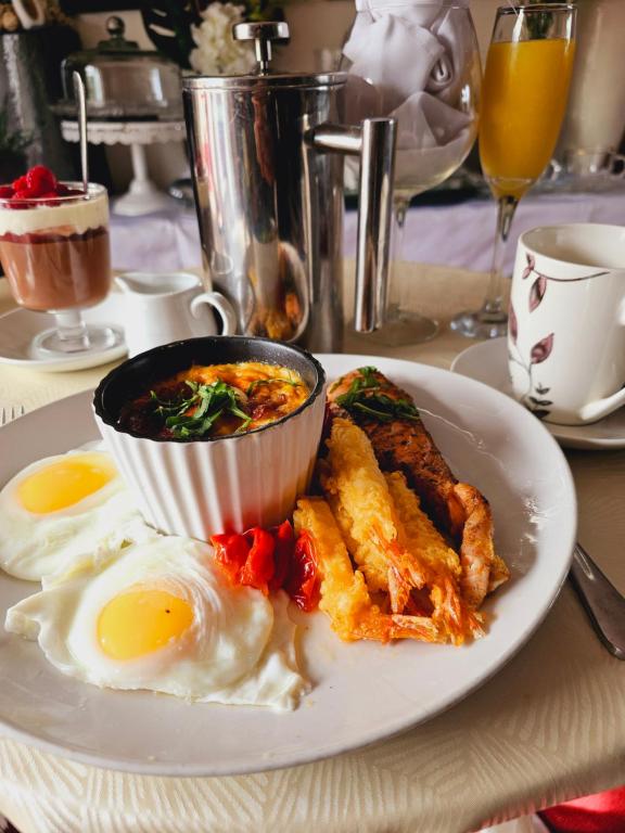 a plate of food with eggs and meat on a table at Cuisinease in Ollerton