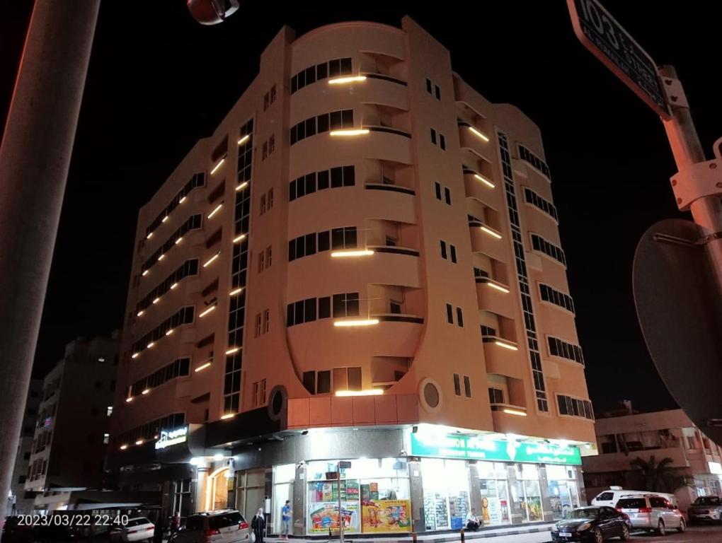 阿吉曼的住宿－AL MARJAN FURNISHED APARTMENTS，前面有一间商店的高楼