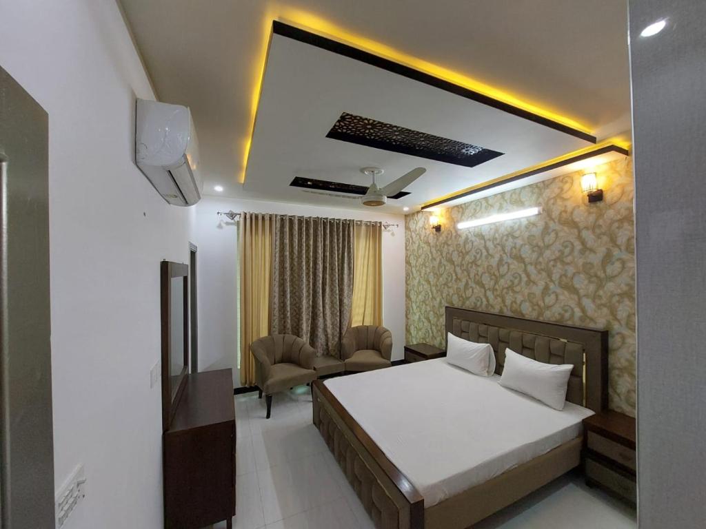 - une chambre avec un lit et un salon dans l'établissement IVY Guest House II, à Islamabad