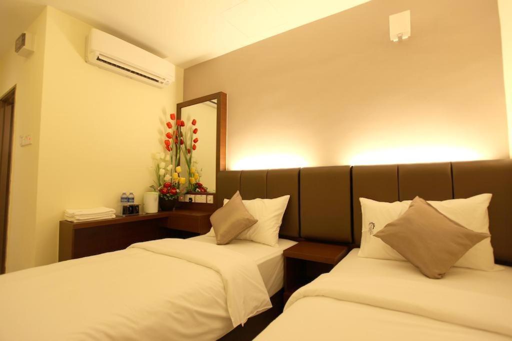 two beds in a room with a mirror at AVARIA SIGNATURE in Melaka