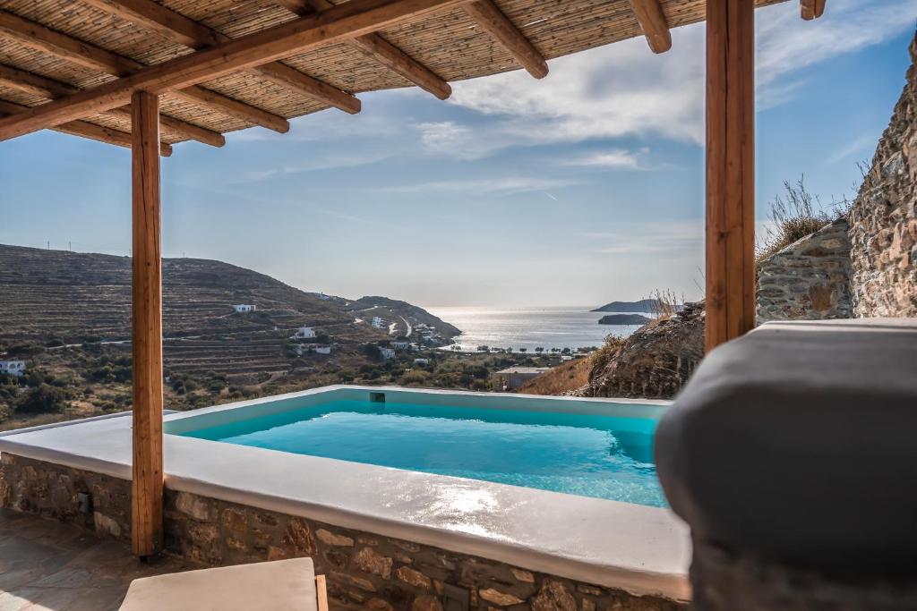una piscina en una casa con vistas al océano en Epithea Suites Kythnos 5 με ιδιωτική πισίνα en Kíthnos