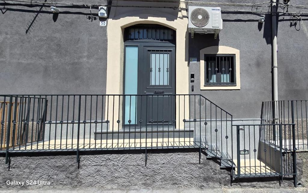 eine Eingangstür eines Hauses mit einer Treppe und einer Tür in der Unterkunft Gesuiti Home di Agata e Aurora in Catania