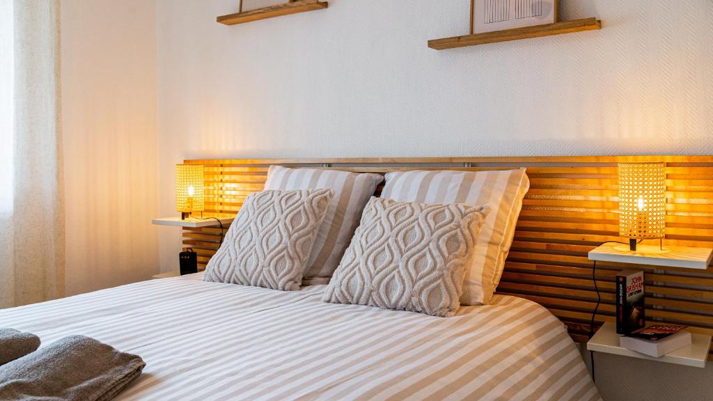 une chambre avec un lit avec deux oreillers et deux lampes dans l'établissement L Appart de Lilou : Paisible / Confort /Proche Centre Ville, à Dijon