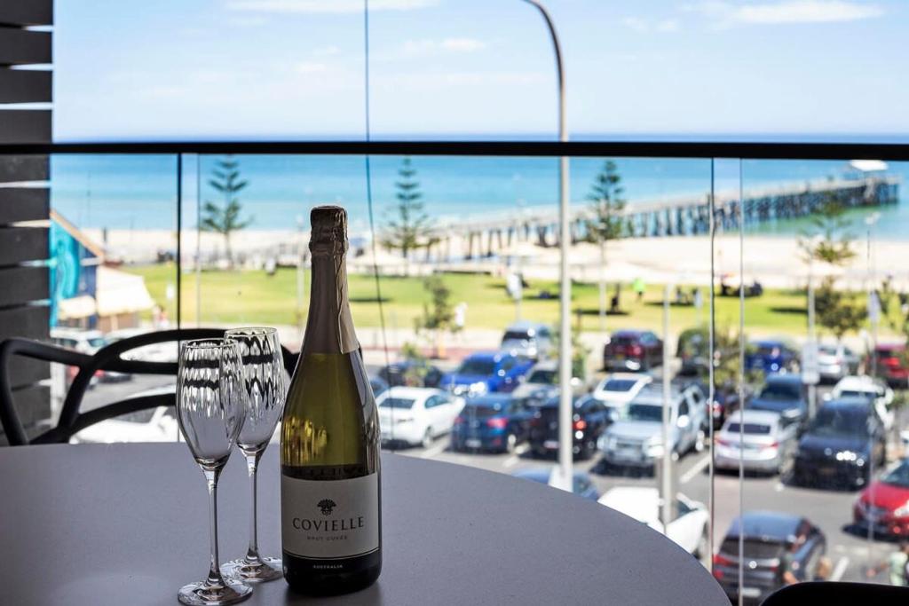 a bottle of wine and a wine glass on a table at The Sandpiper Sanctuary at Henley Beach in Henley Beach South