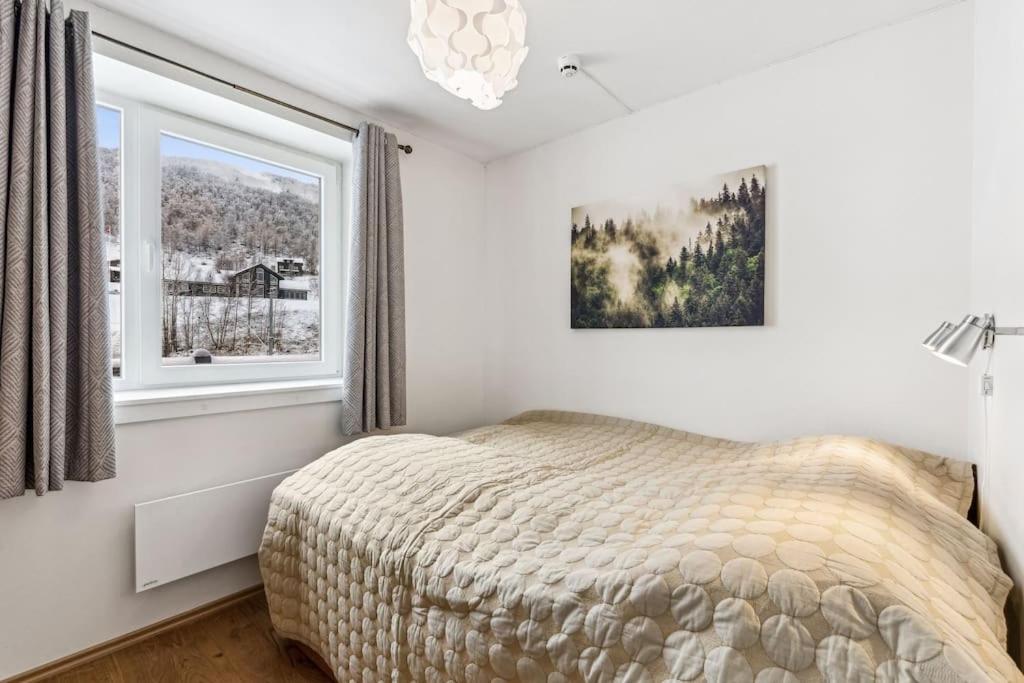 um quarto com uma cama e uma janela em Moderne og sentral leilighet på Geilo em Geilo