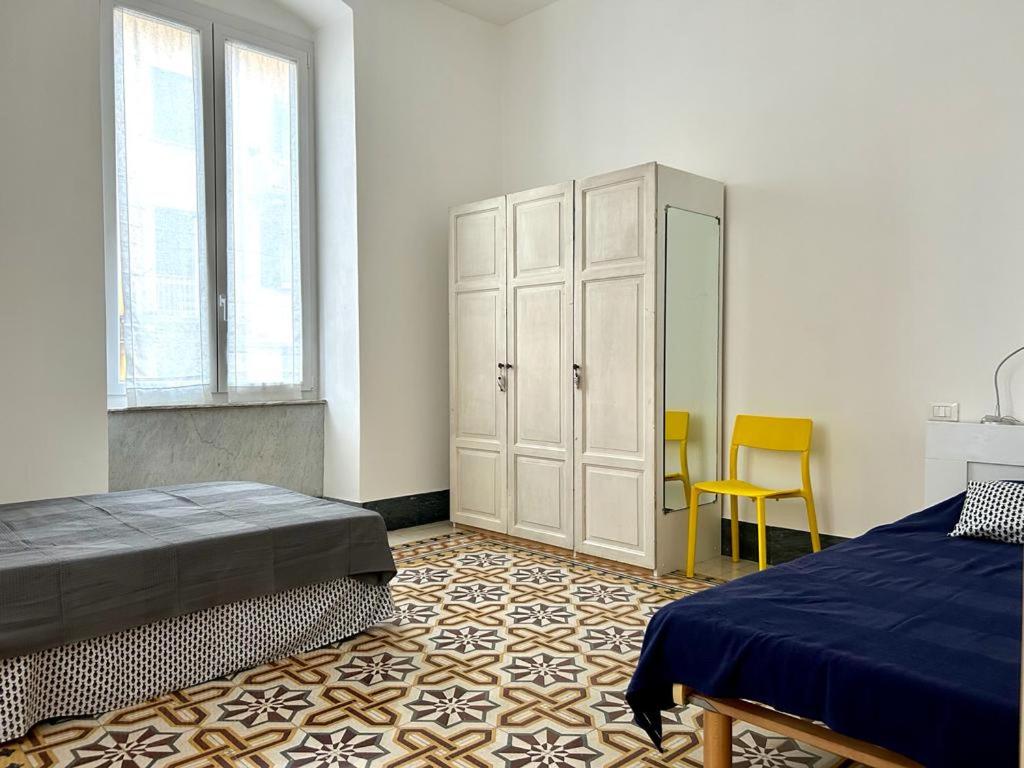 1 dormitorio con 1 cama, armario y sillas en aCàToa - spacious bright apartment in the city center 3 bedrooms - La Spezia / easy access and connections to 5 Terre and Portovenere, en La Spezia