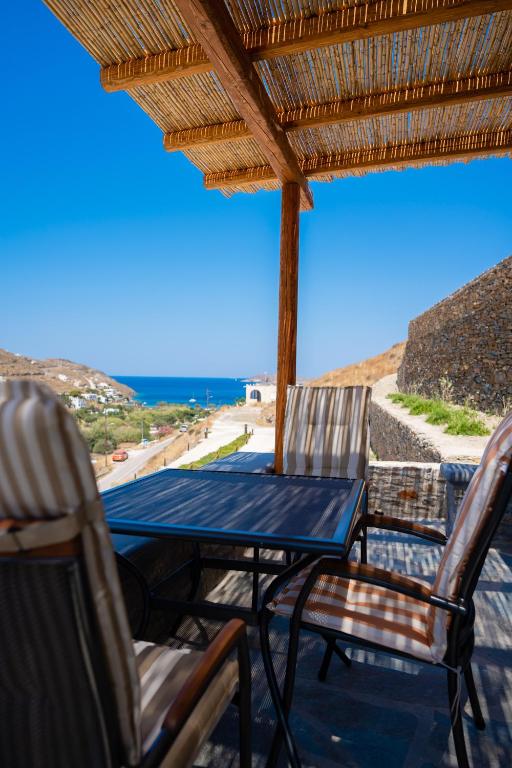a table and chairs on a patio with a view of the ocean at Epithea Suites Kythnos Keli in Kithnos
