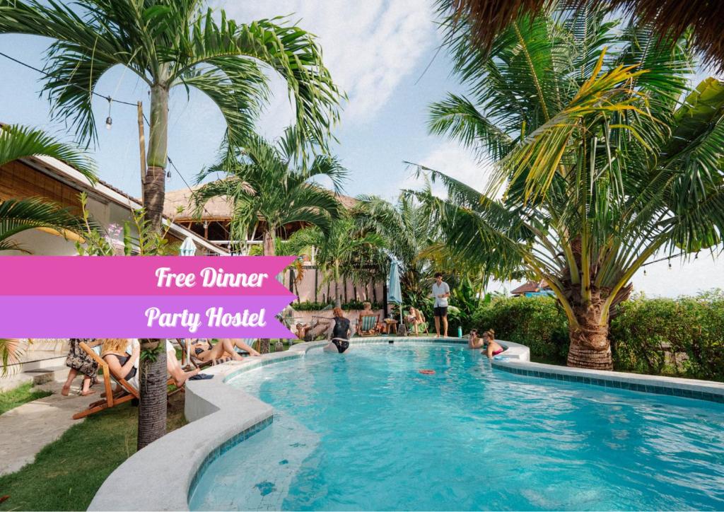 uma piscina num resort com palmeiras em Clandestino Hostel Canggu em Canggu