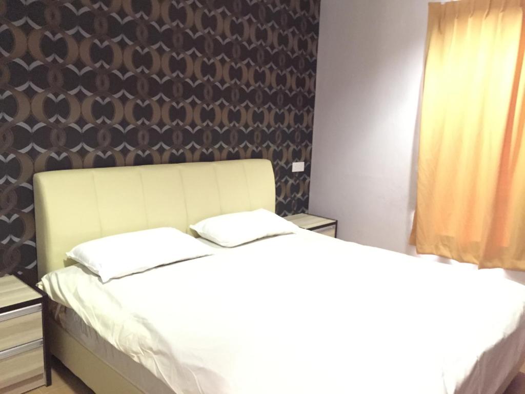a bedroom with two beds and a wall at Tas Sakura Budget Hotel in Kampong Baharu