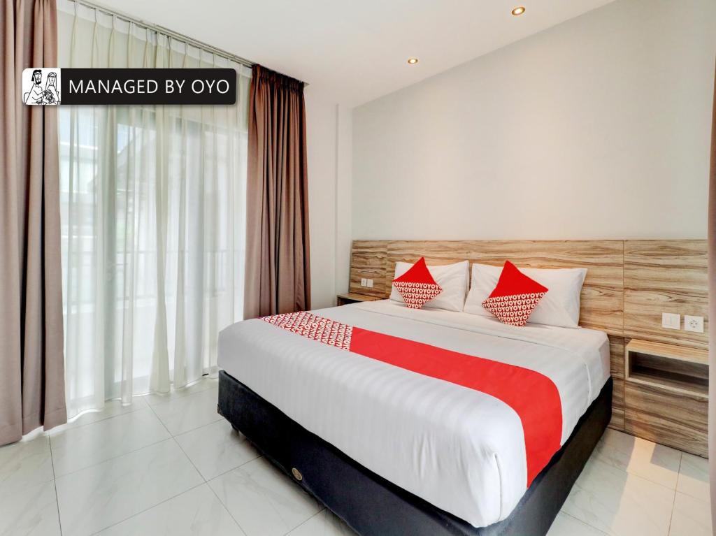 una habitación de hotel con una cama grande con almohadas rojas en Super OYO Flagship 90775 I Sleep Hotel Bandung, en Bandung
