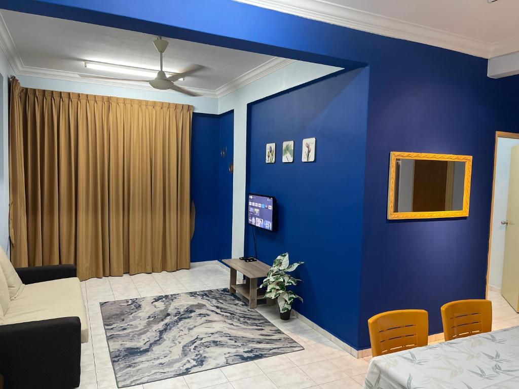 um quarto azul com uma cama e uma parede azul em Serene Bukit Beruang Cottage 4 ROOMS FULL AIRCOND & NETFLIX by EZYROOM MELAKA em Ayer Keroh