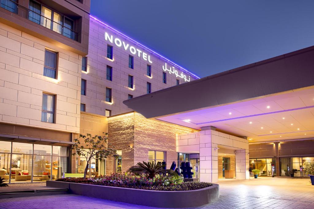 hotel przed budynkiem w nocy w obiekcie Novotel Muscat Airport w Maskacie