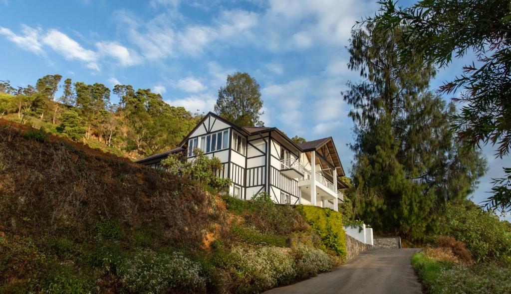 a house on a hill next to a road at W15 Glenfall Nuwara Eliya in Nuwara Eliya