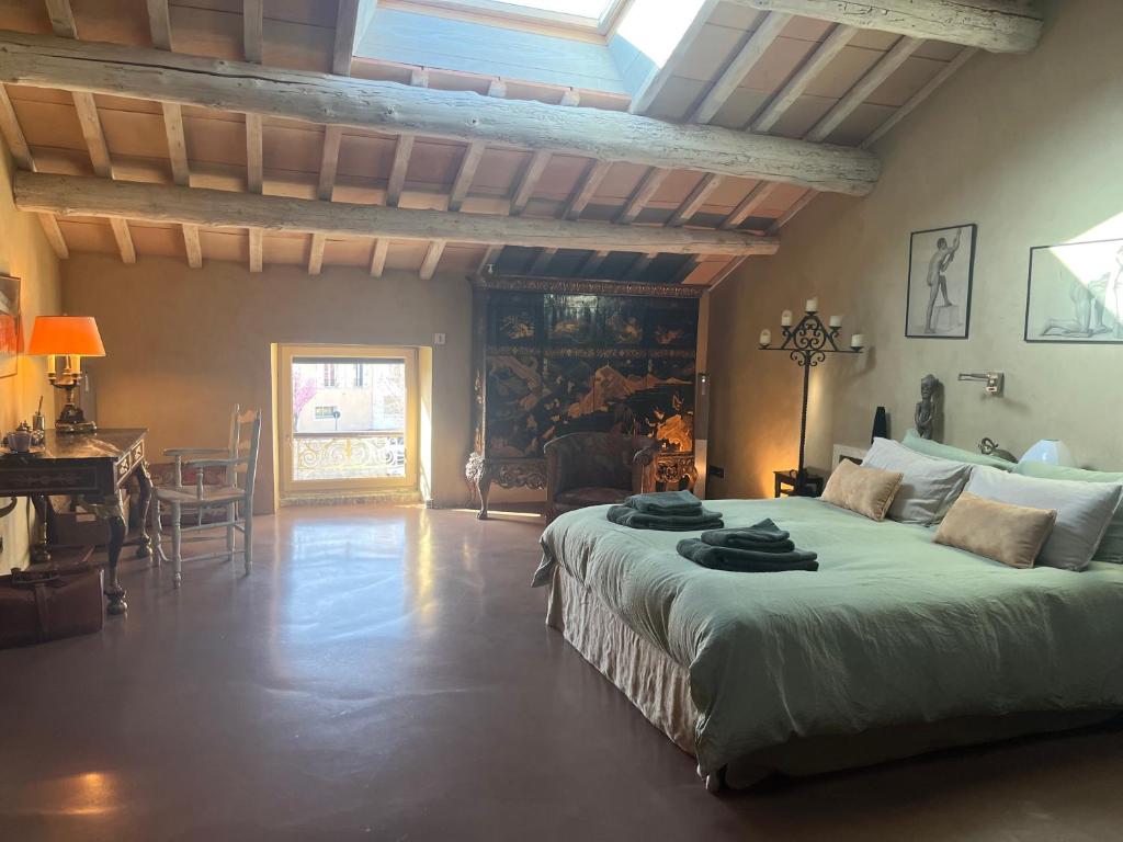 a bedroom with a large bed in a room with a table at Maison en Provence in Lapalud