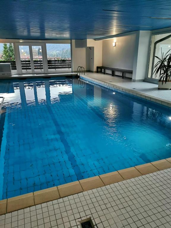a large swimming pool with blue water in a building at Fewo Alpenblick | Pool | Bergblick in Berchtesgaden