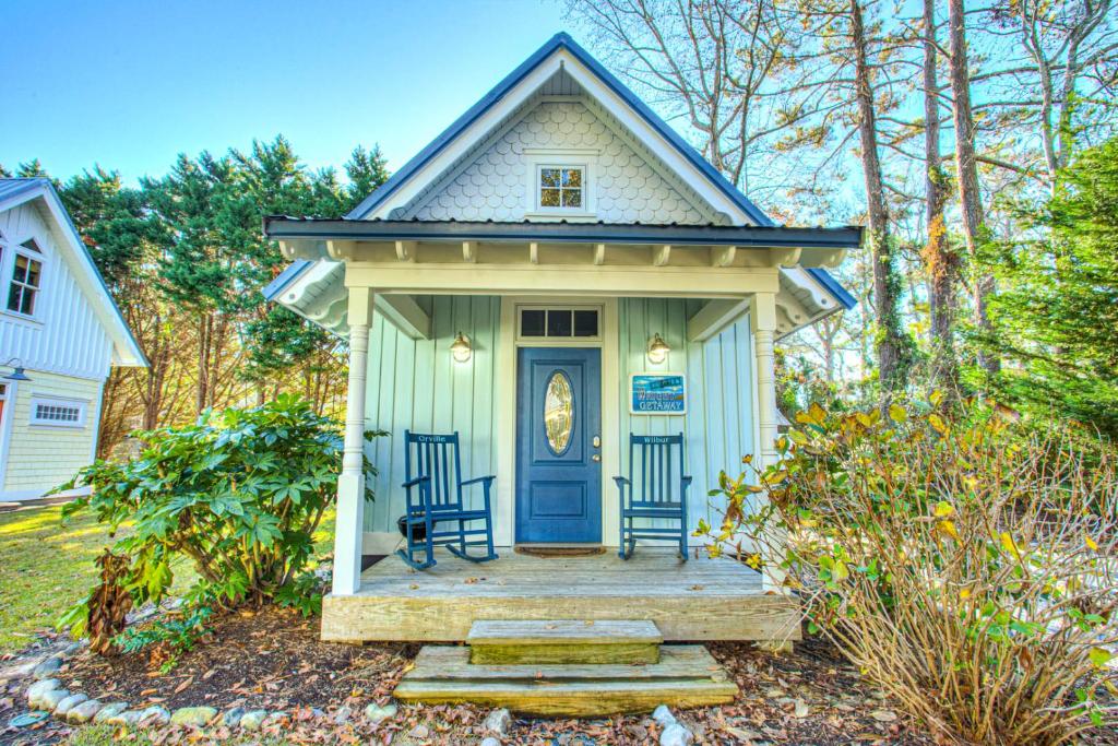 a tiny house with two chairs on a porch at IC3 The Wright Getaway Dog Friendly in Manteo