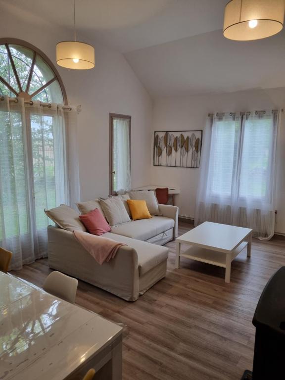 ein Wohnzimmer mit einem Sofa und einem Tisch in der Unterkunft Gîte du Grand frêne in Orrouy