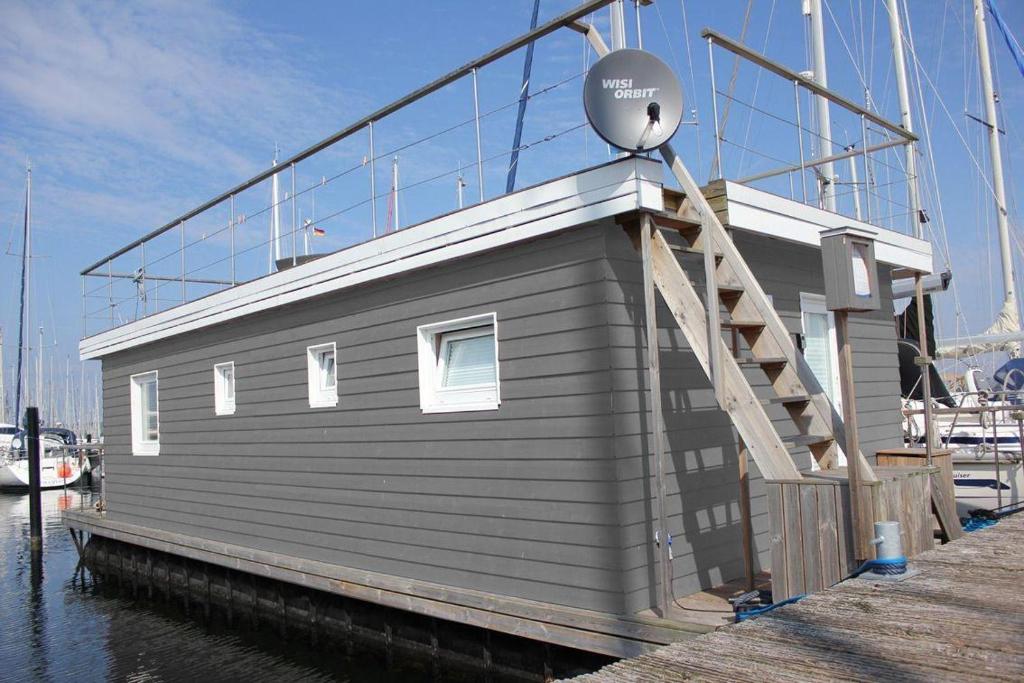 una pequeña casa en un barco en el agua en Koje-KALLE, en Heiligenhafen