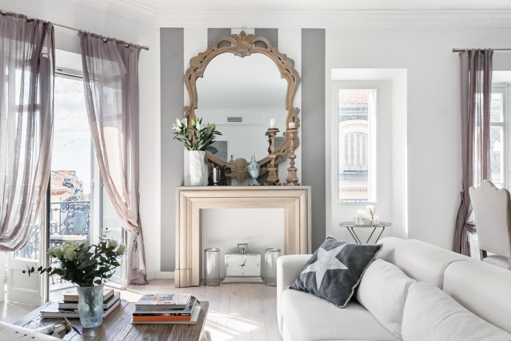 a living room with a white couch and a mirror at Royal penthouse, comfort and luxury in Cannes