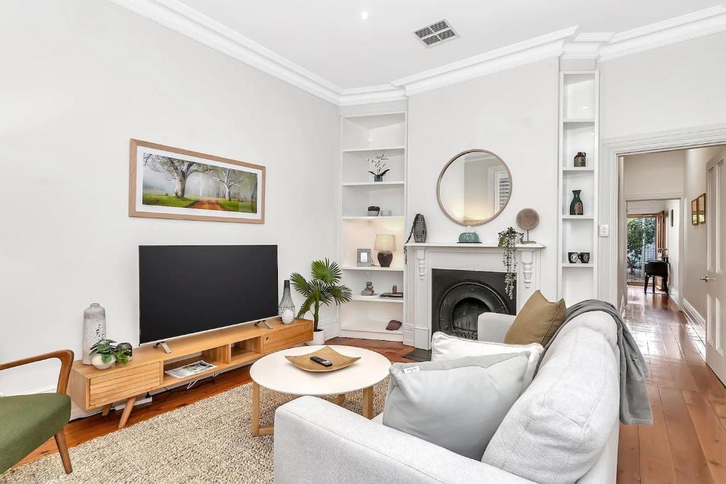 a living room with a couch and a tv at 'The Cosy Corner' Classic Haven with Modern Comforts in Adelaide