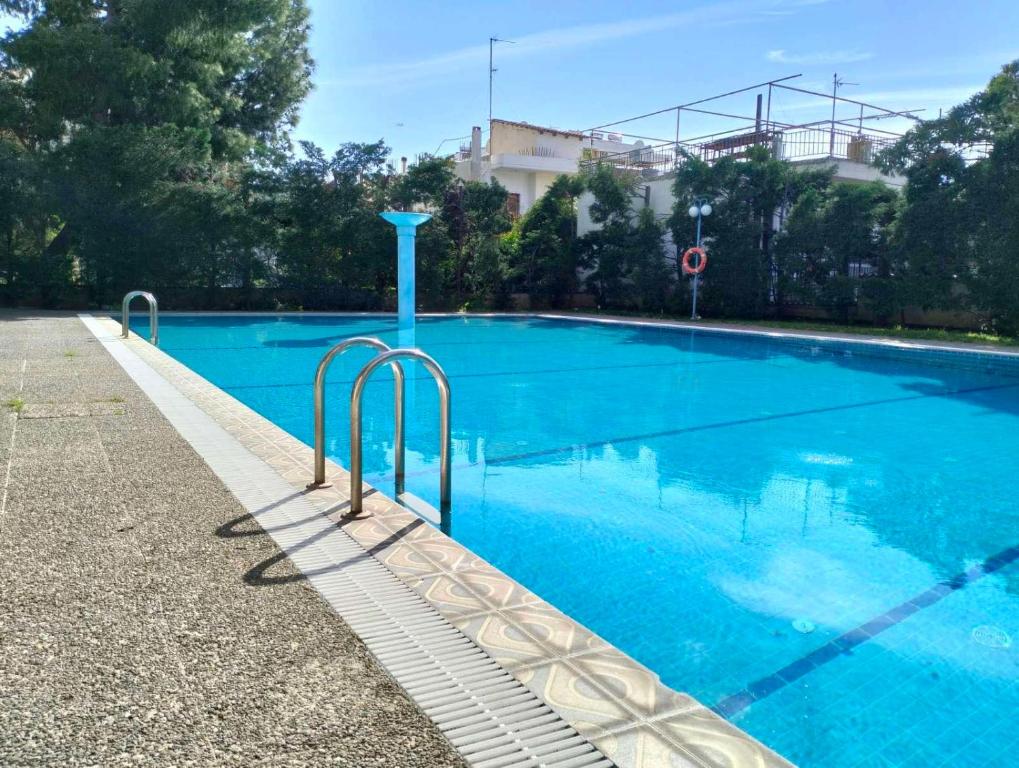 a large swimming pool with blue water at NikhsHome in Loutraki