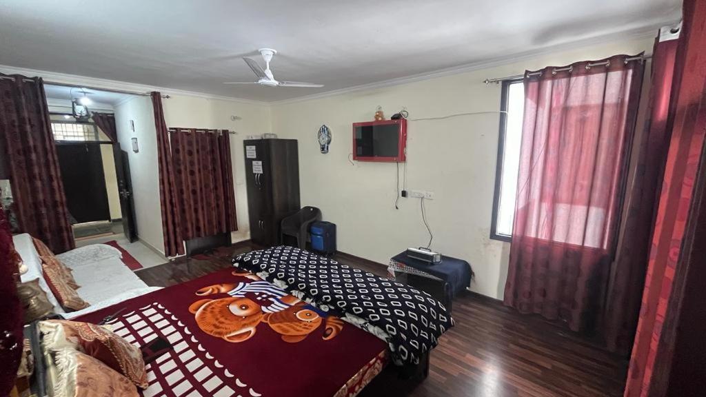 a bedroom with a bed and a tv on the wall at Nainital Homes in Bhowāli