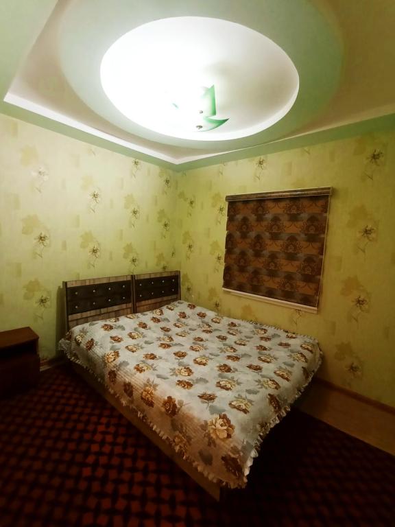 um quarto com uma cama com uma luz no tecto em DOM V CHIMGANE em Kyzyldzhar