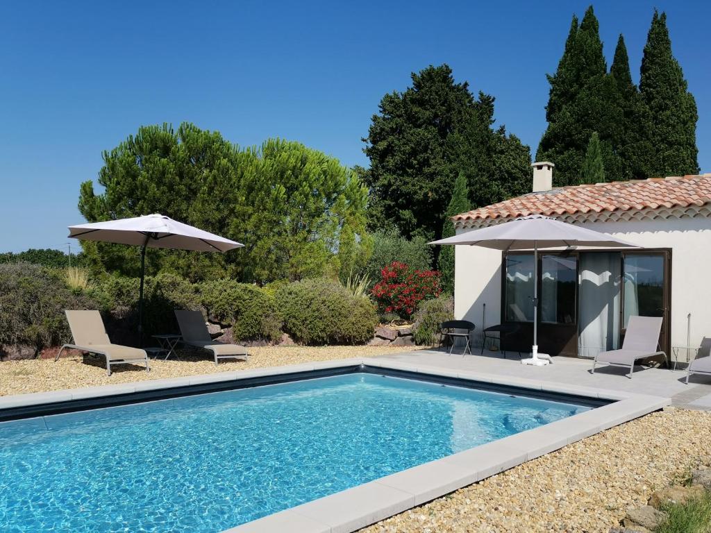 une piscine devant une villa dans l'établissement Le Domaine de Tini, à Violès