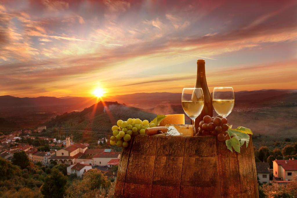 una bottiglia di vino e un piatto di uva e bicchieri da vino di Nice and cozy appartment Innside photos are coming soon a Dogliani