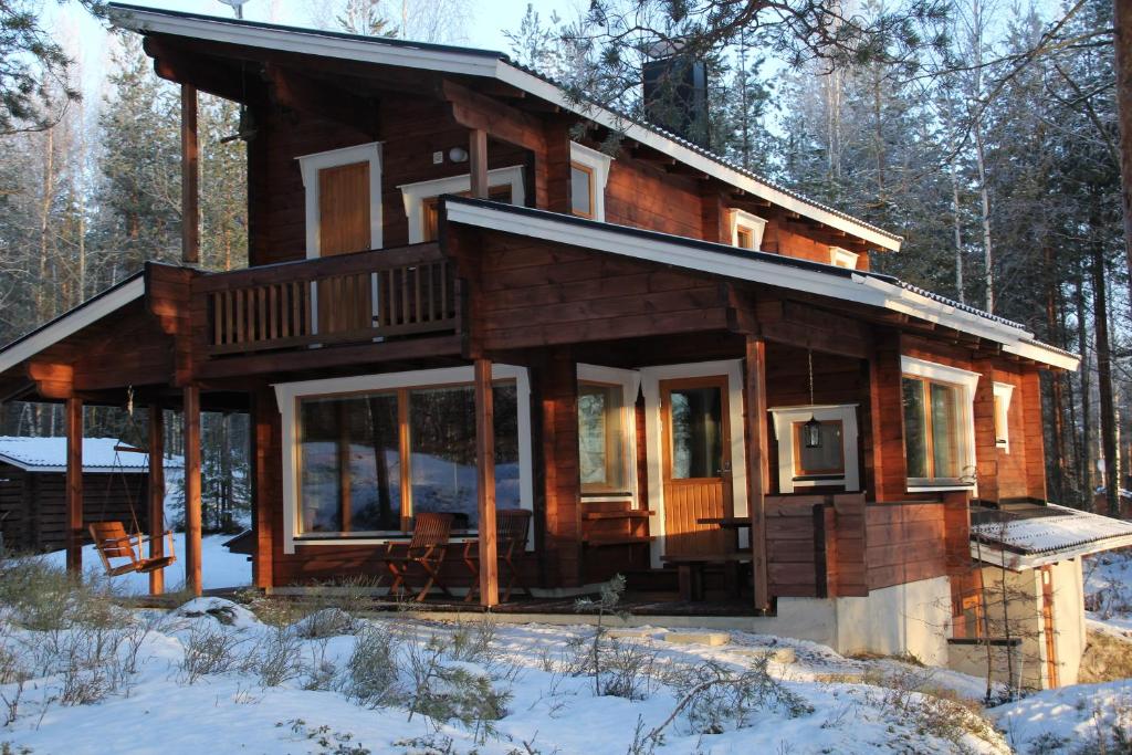 a log cabin in the woods in the snow at Okkolan Lomamökit in Puumala