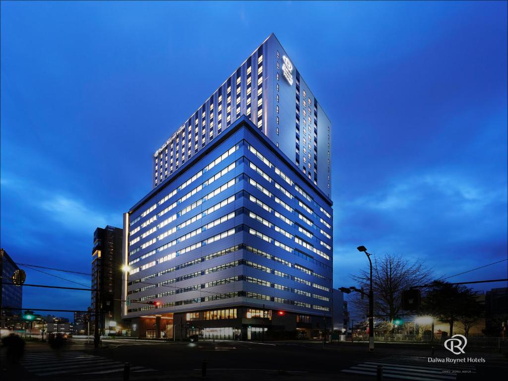 wysoki budynek z wieloma oknami w nocy w obiekcie Daiwa Roynet Hotel Omiya-nishiguchi w mieście Saitama