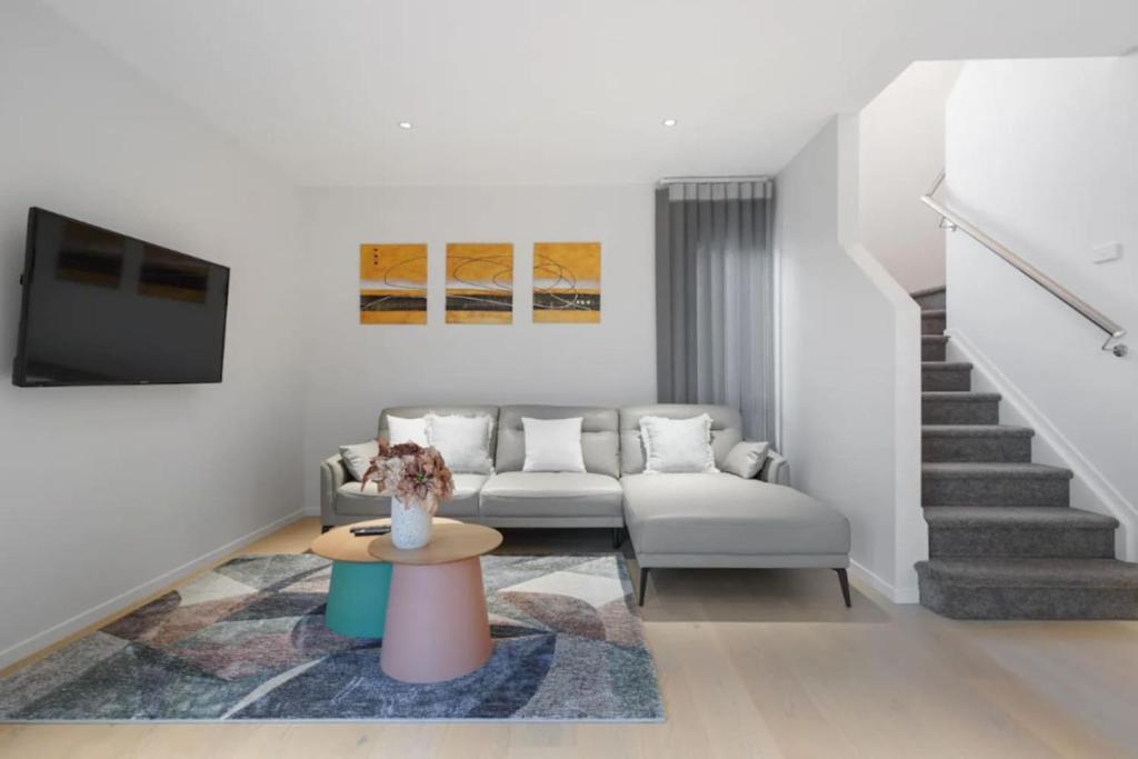 a living room with a couch and a table at Stunning Luxe Home Near Airport in Auckland