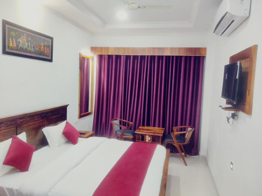 um quarto com uma cama grande e uma cortina roxa em THE HAMIRGARH PALACE em Rājsamand