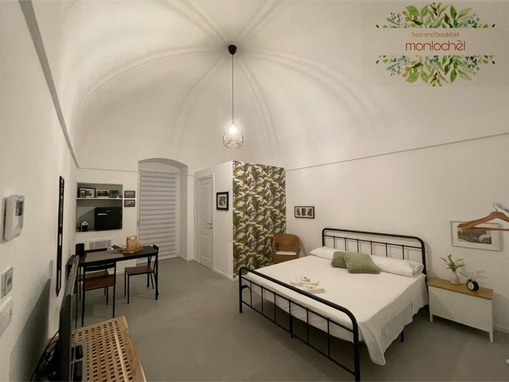 ein Schlafzimmer mit einem Bett und einem Schreibtisch in einem Zimmer in der Unterkunft Monlochèl in Noci