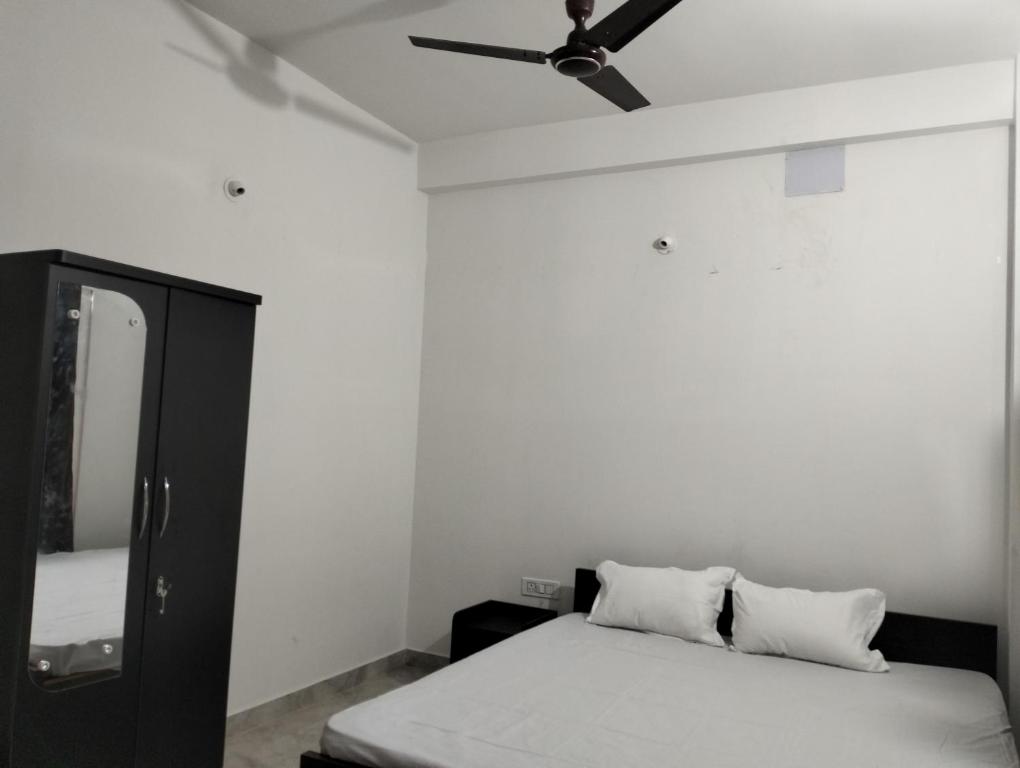 a bedroom with a bed and a ceiling fan at RNK HOMESTAY in Guwahati