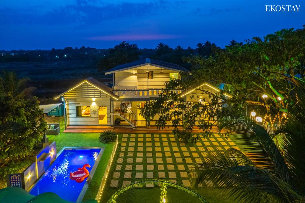 uma vista aérea de uma casa com piscina à noite em EKO STAY- Lakefront Villa em Alibaug