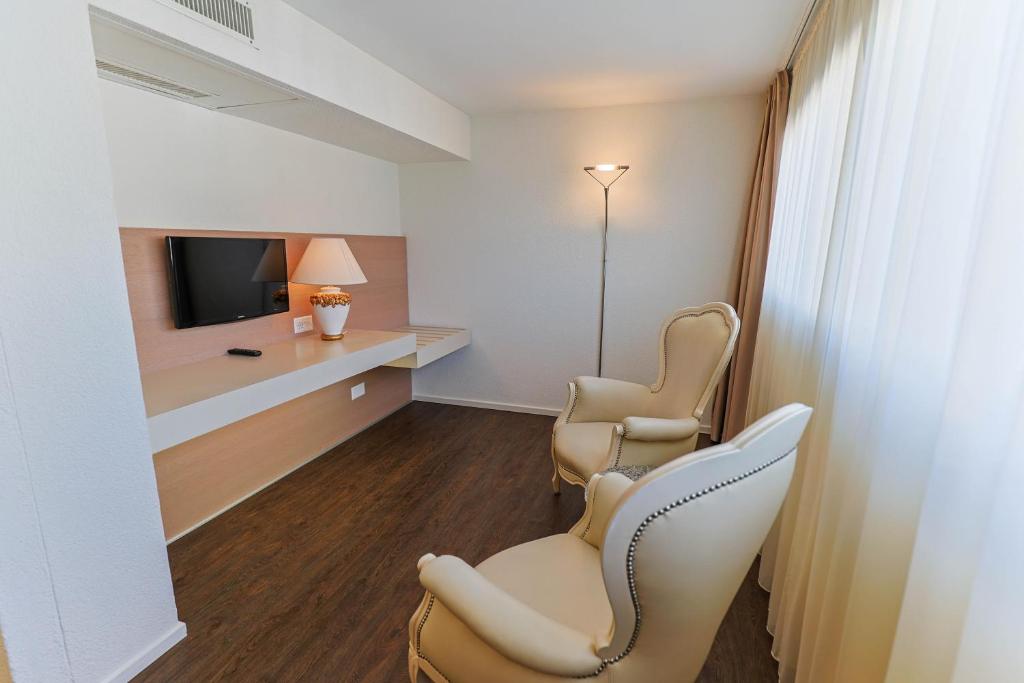 a waiting room with two chairs and a tv at Hotel Muralto Locarno in Locarno