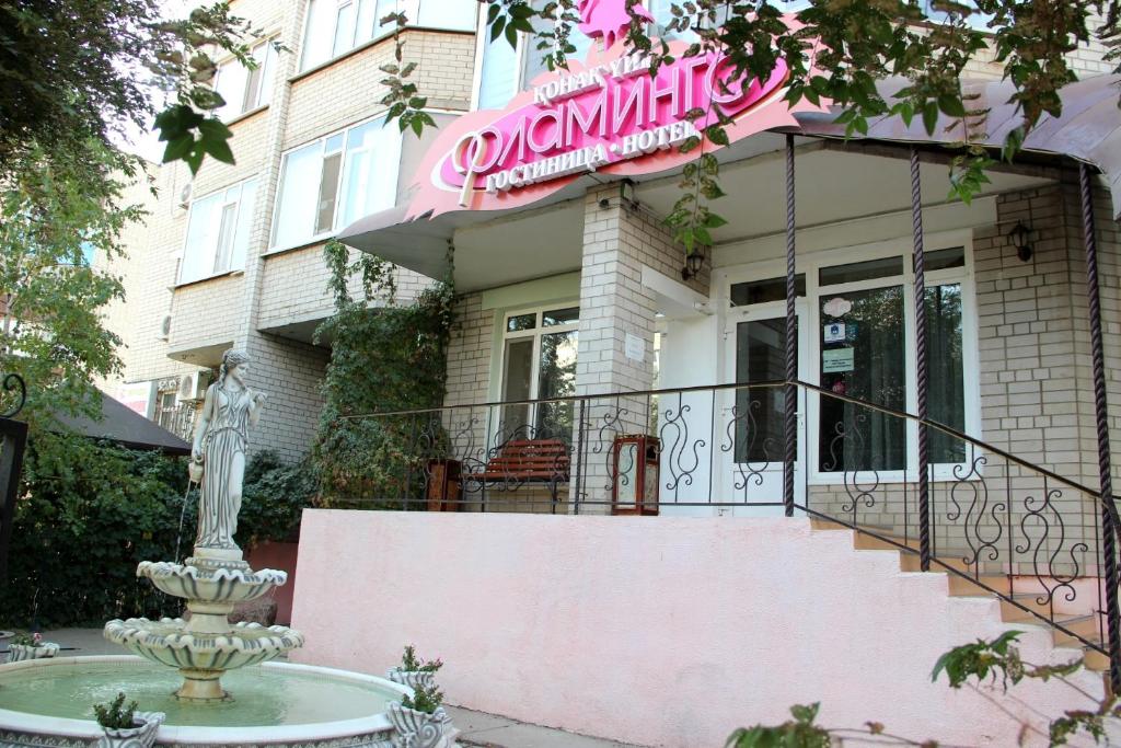 a pink house with a fountain in front of it at Flamingo in Aktobe