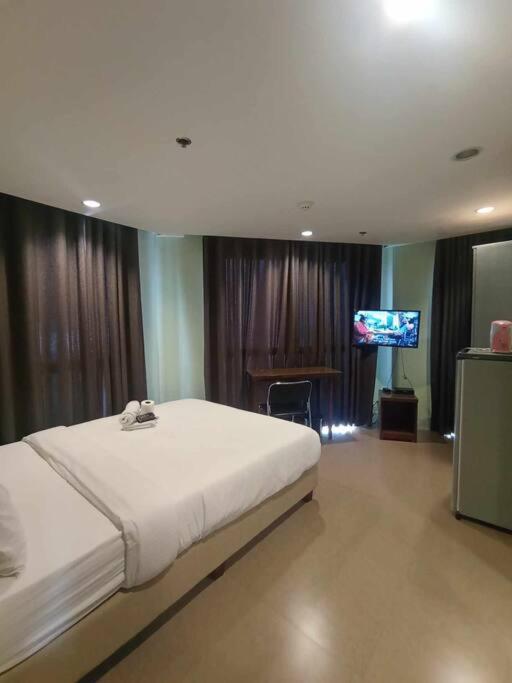 a bedroom with a large bed and a television at Spacious Studio Apartment B502 in Manila